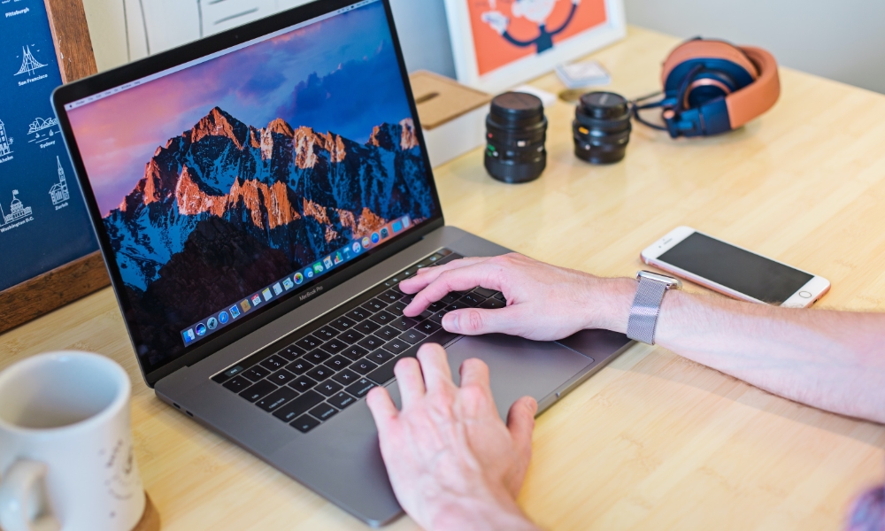 person using MacBook at desk