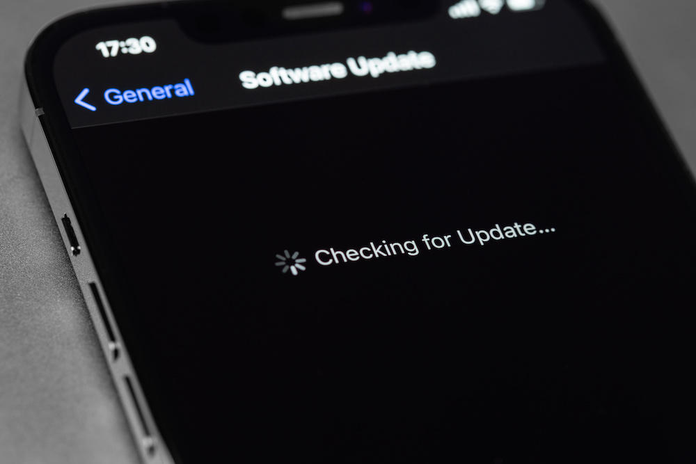 iPhone with Settings, iOS update on screen, Checking for Update. Apple is a multinational technology company. Moscow, Russia September 5, 2021