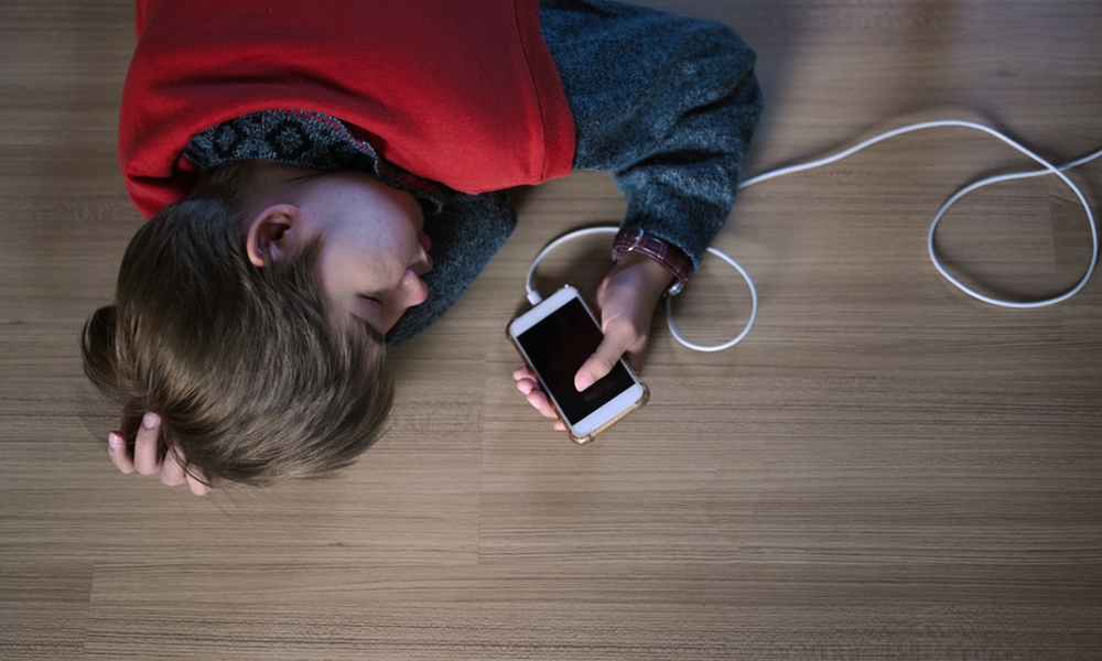 person laying on floor holding iPhone
