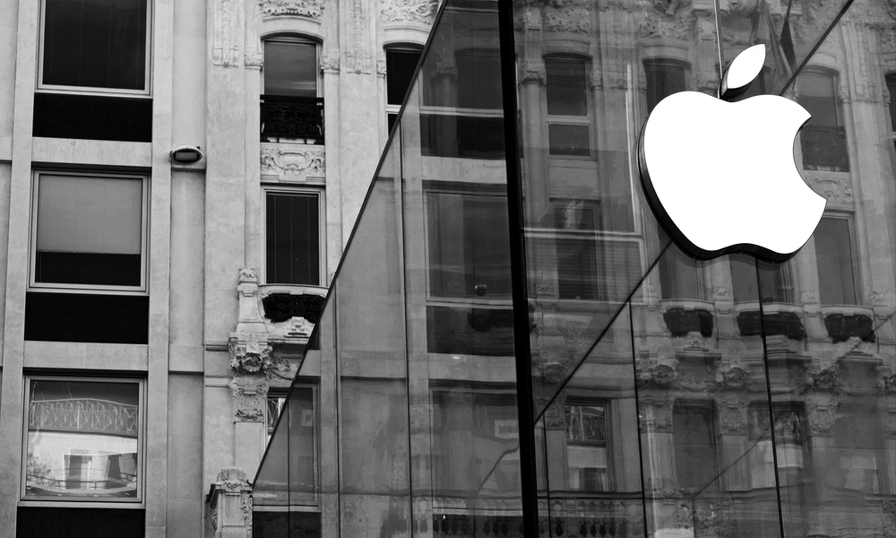 Apple logo on glass facade in front of older building