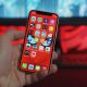 person holding iPhone showing home screen