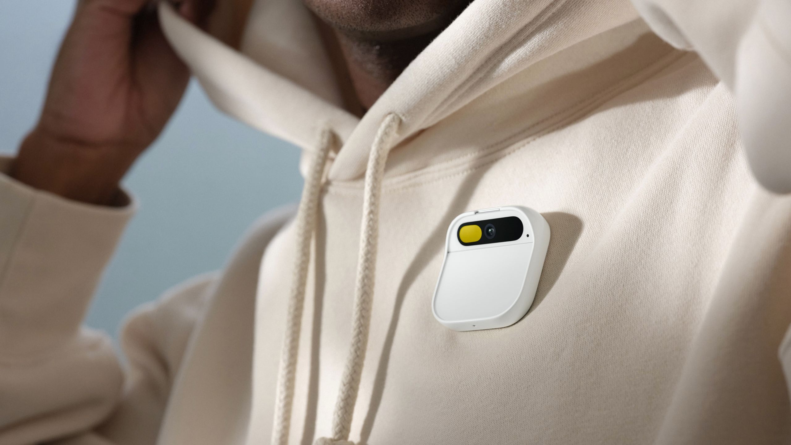 White Humane Ai Pin pinned to a white hoodie