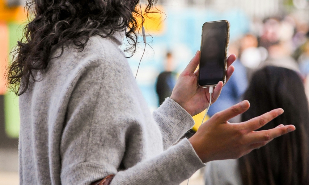 person holding iPhone and gesturing on video call