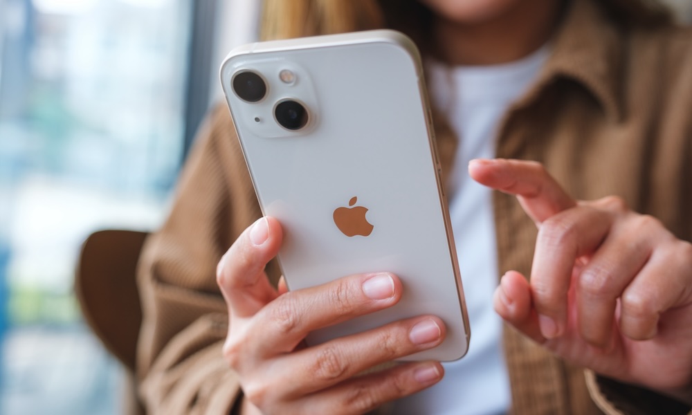 Oct 6th 2022 : A woman holding and touching on Iphone 13 smart phone screen, Chiang mai Thailand