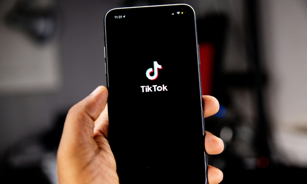 person holding iPhone with TikTok logo