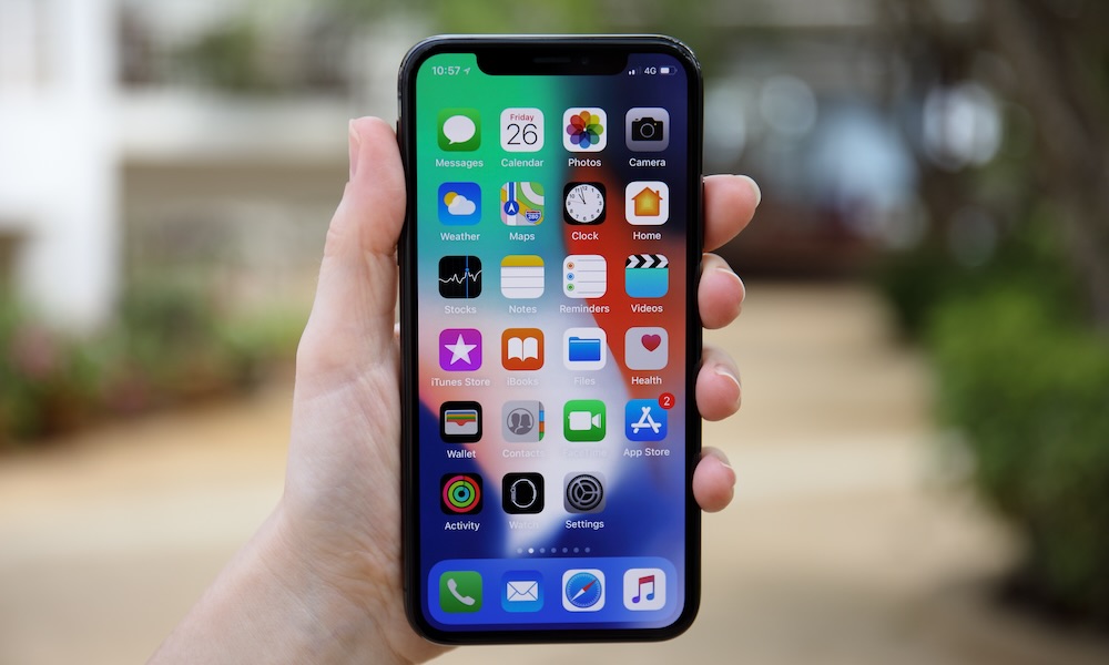 Woman hand holding iPhone X with IOS 11 on screen Woman hand holding iPhone X with IOS 11 on screen