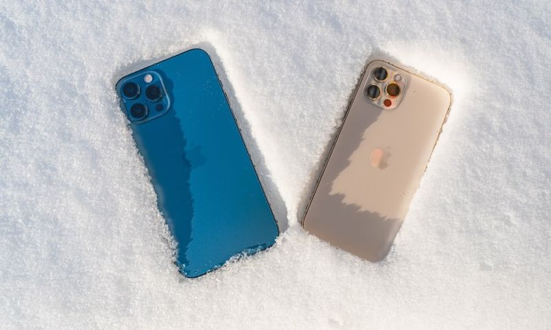 BERLIN, GERMANY January 31.,2021. iPhone 12 Pro Max pacific blue and iPhone 12 PRO gold in the snow. Snowflake on the mobile phone