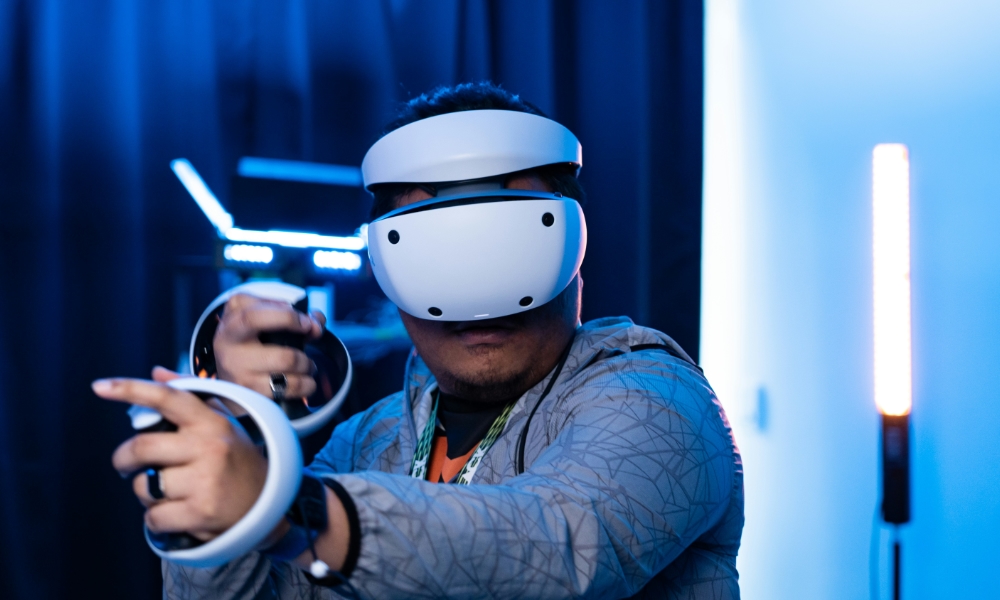 man wearing Sony PlayStation VR2 in gaming pose