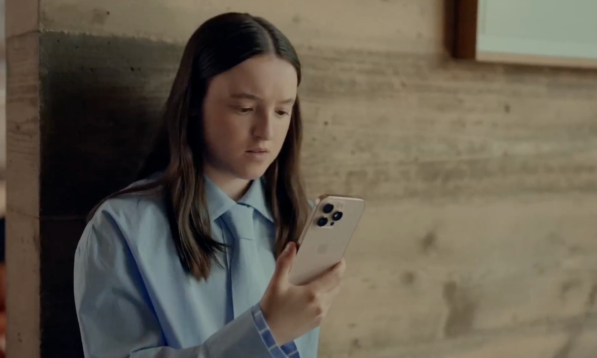 Apple ad Bella Ramsey looking at iPhone
