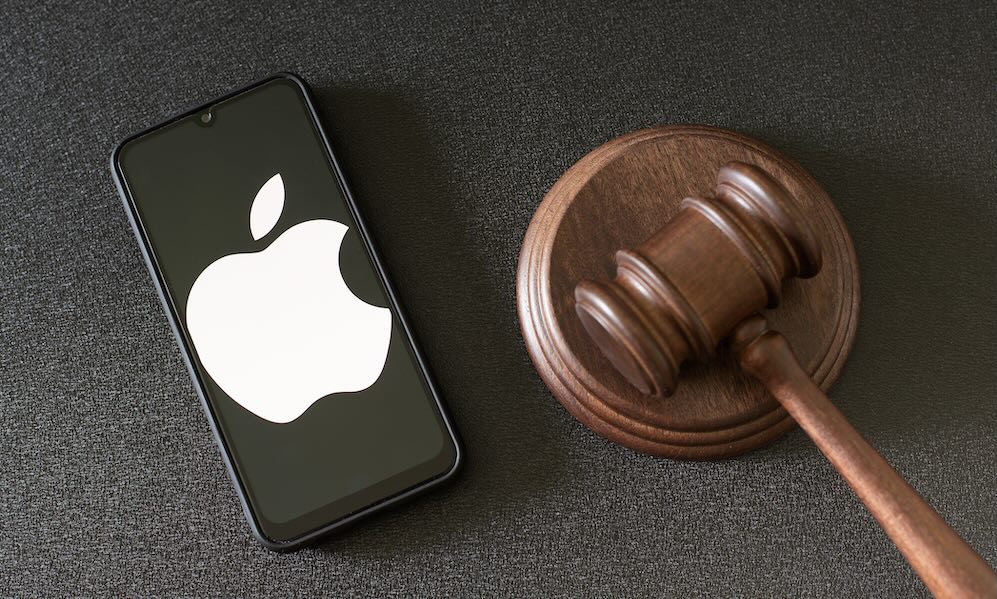 KHARKOV, UKRAINE JUNE 25, 2020: Apple logo seen on smartphone screen and Judge gavel.