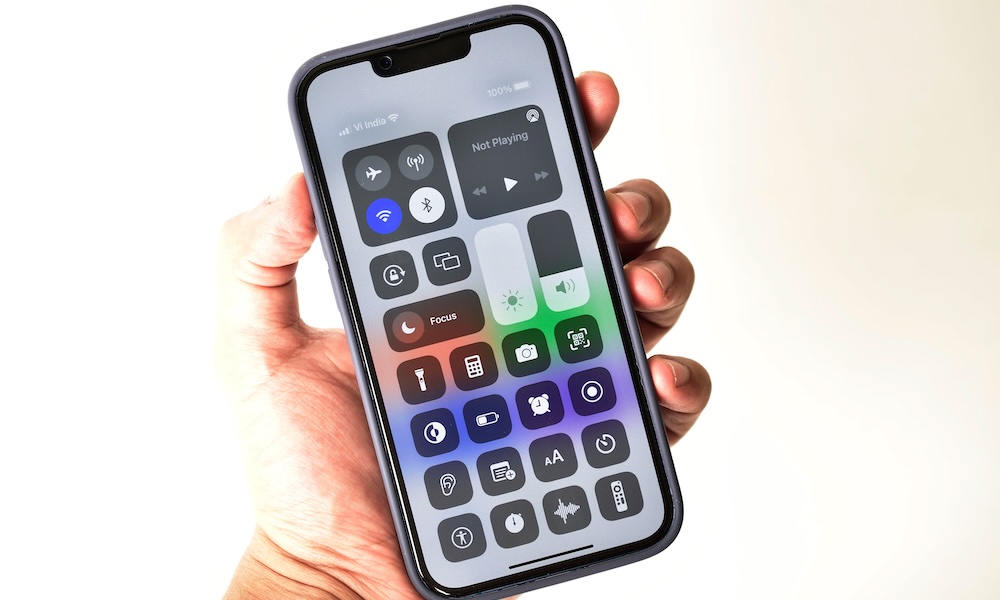 Control center in hand holding iphone 13 isolated on white background