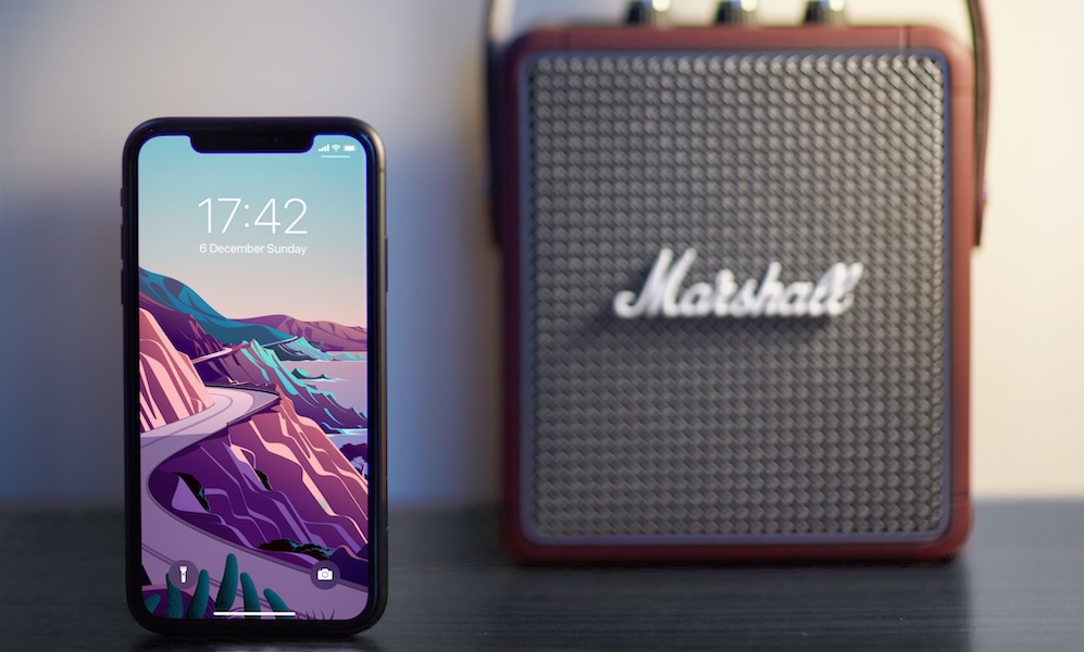Marshall Stockwell II Bluetooth speaker with iPhone11 Black is standing on the desk, blurry background and object. 06.12.2020 Bornova Izmir Turkey
