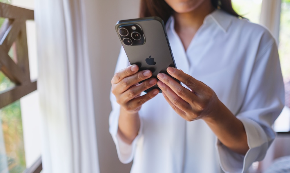 Mar 4th 2025 : A woman holding and using Iphone 15 Pro Max smart phone at home, Chiang mai Thailand