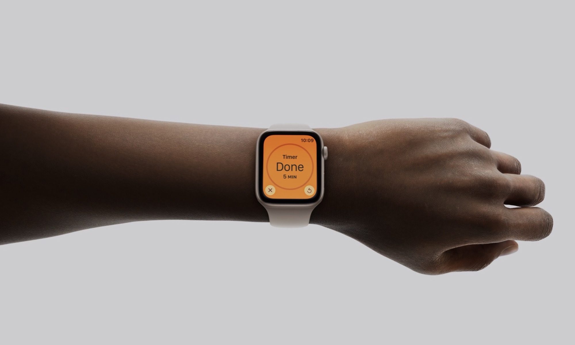 Personal holding out arm with Apple Watch SE 3 showing timer screen.