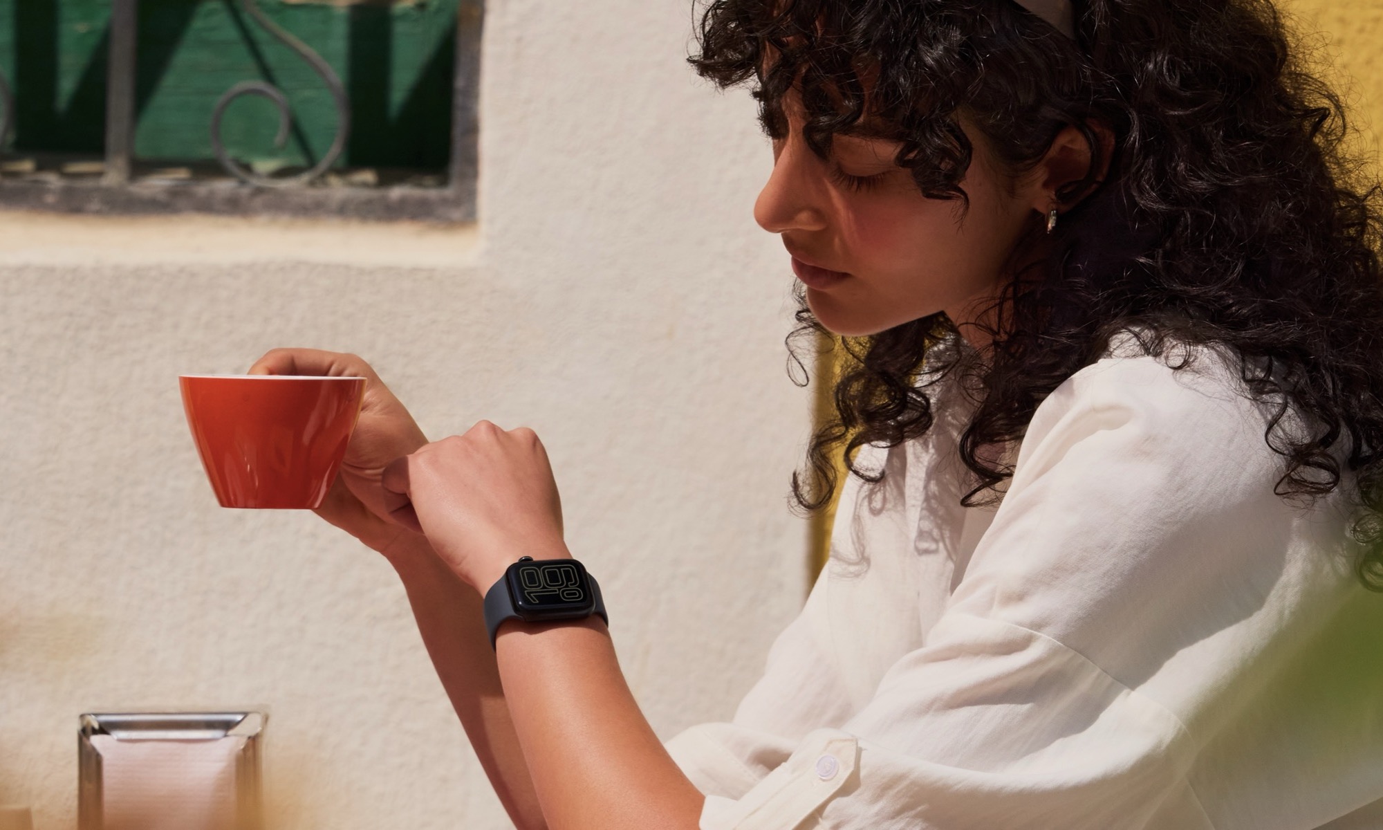 woman in cafe looking at her Apple Watch