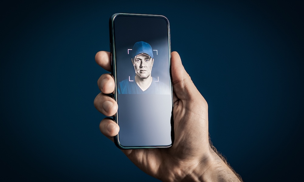 Deep fake or face recognition. AI deepfake or identity verification with phone. Scam, fraud or theft security. ID scan from eye. Man and biometric mobile protection concept. Smartphone in hand.