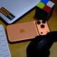 iPhone 17 Pro cosmic orange on desk with laptop keyboard headphones