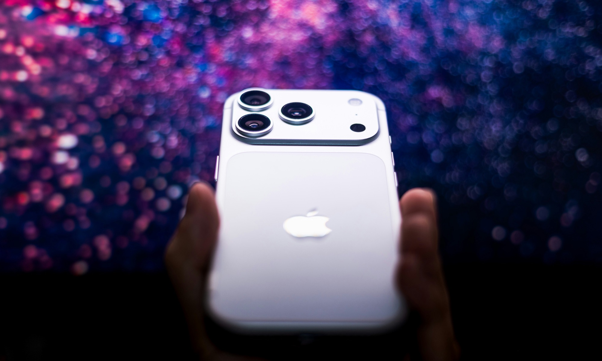 iPhone 17 Pro silver in hand against purple background