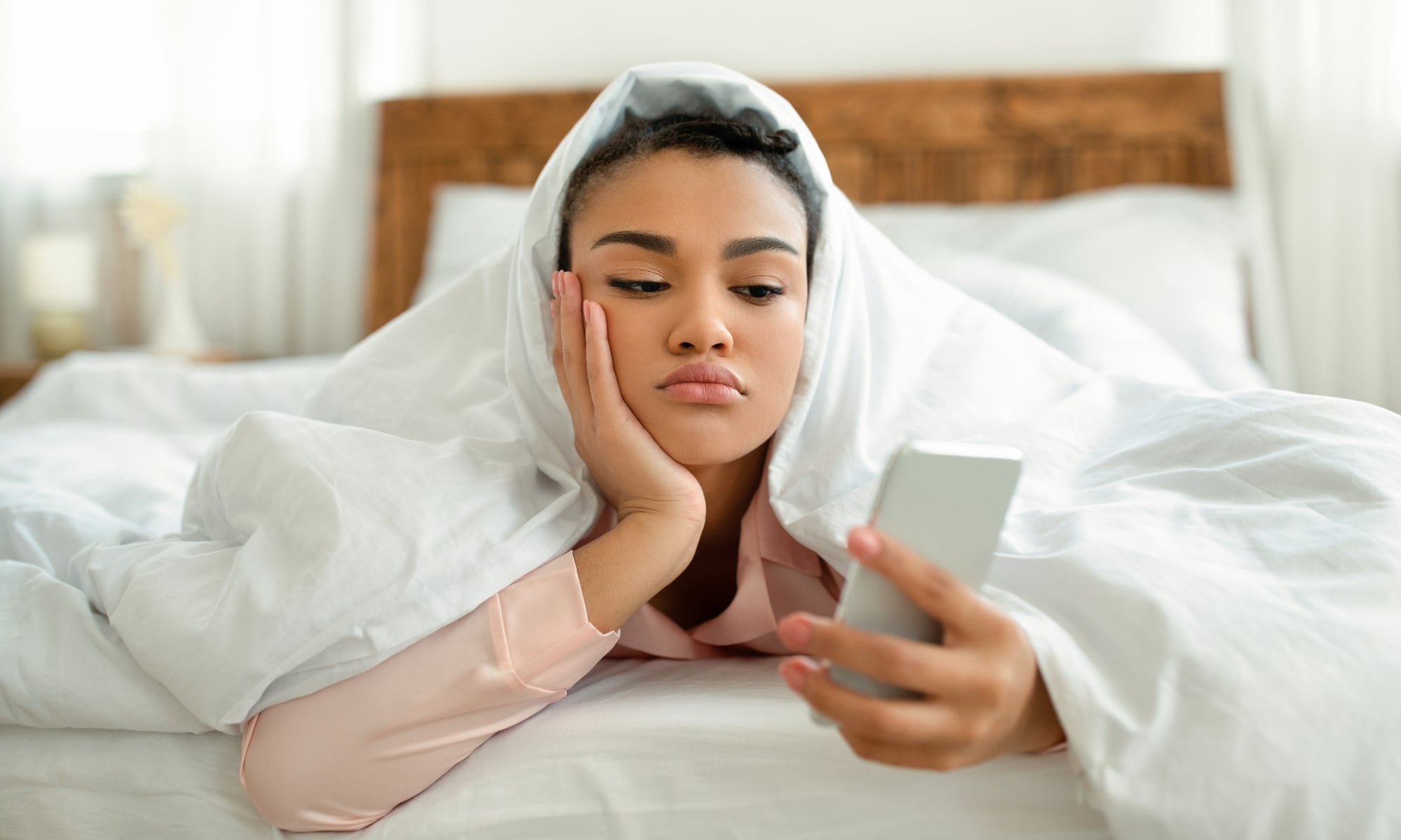 person woman bed phone sad