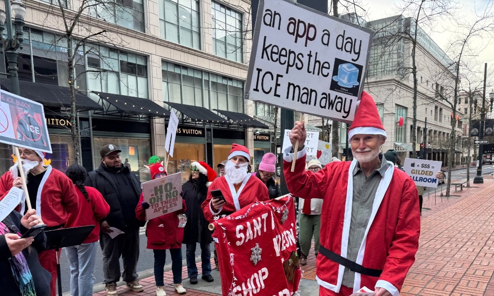 Protestors in Santa costumes demonstrating outside Portland Apple Store.