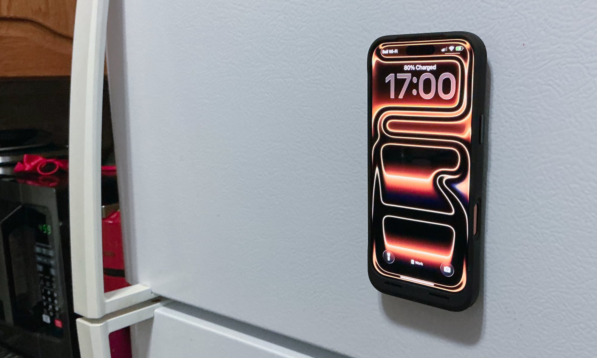iPhone 17 Pro Max in Mophie Juice Pack case magnetically attached to kitchen refrigerator
