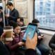 person playing Crossy Road one handed game iPhone subway train transit commute
