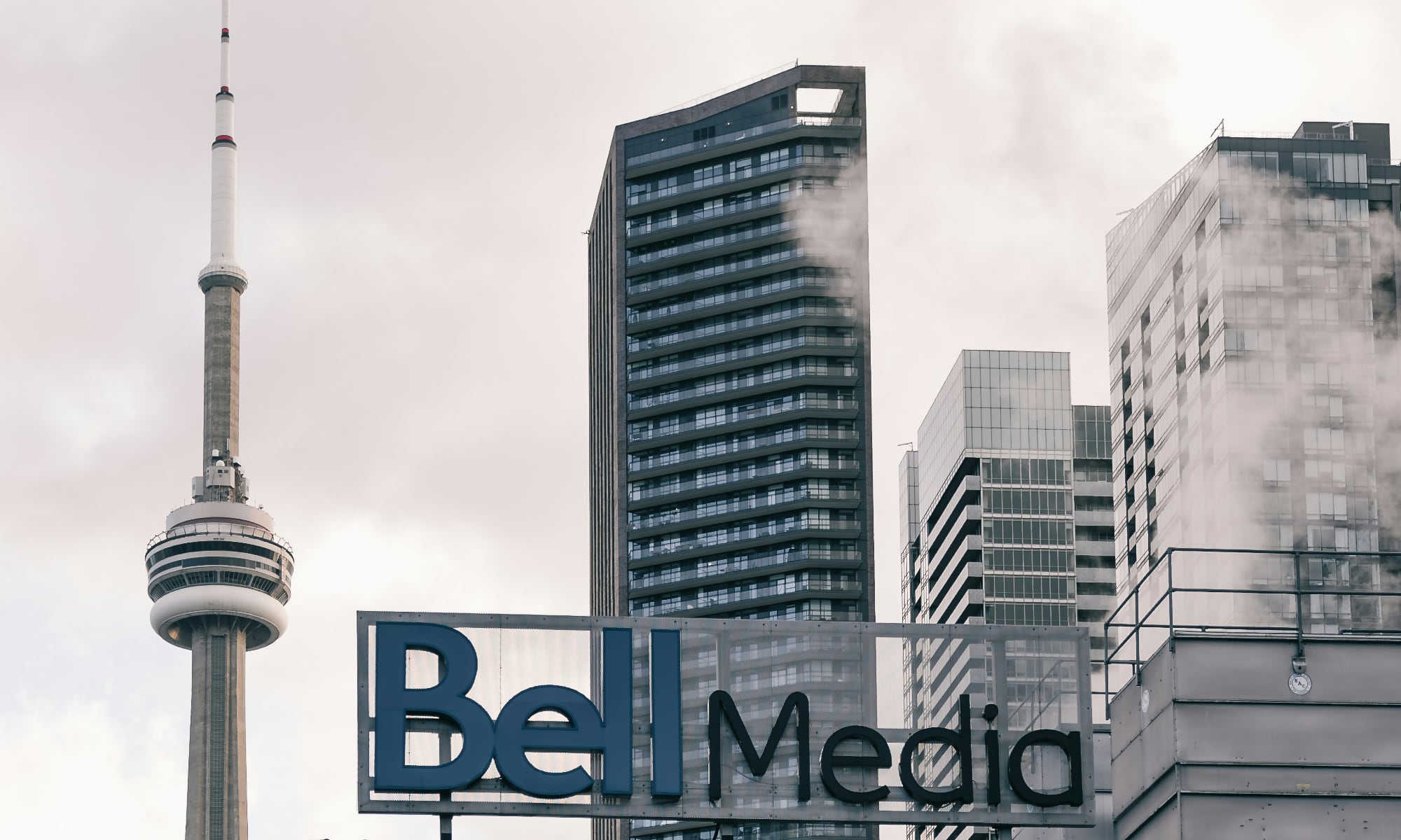 A Bell Media sign in front of the Toronto skyline showing the CN tower.