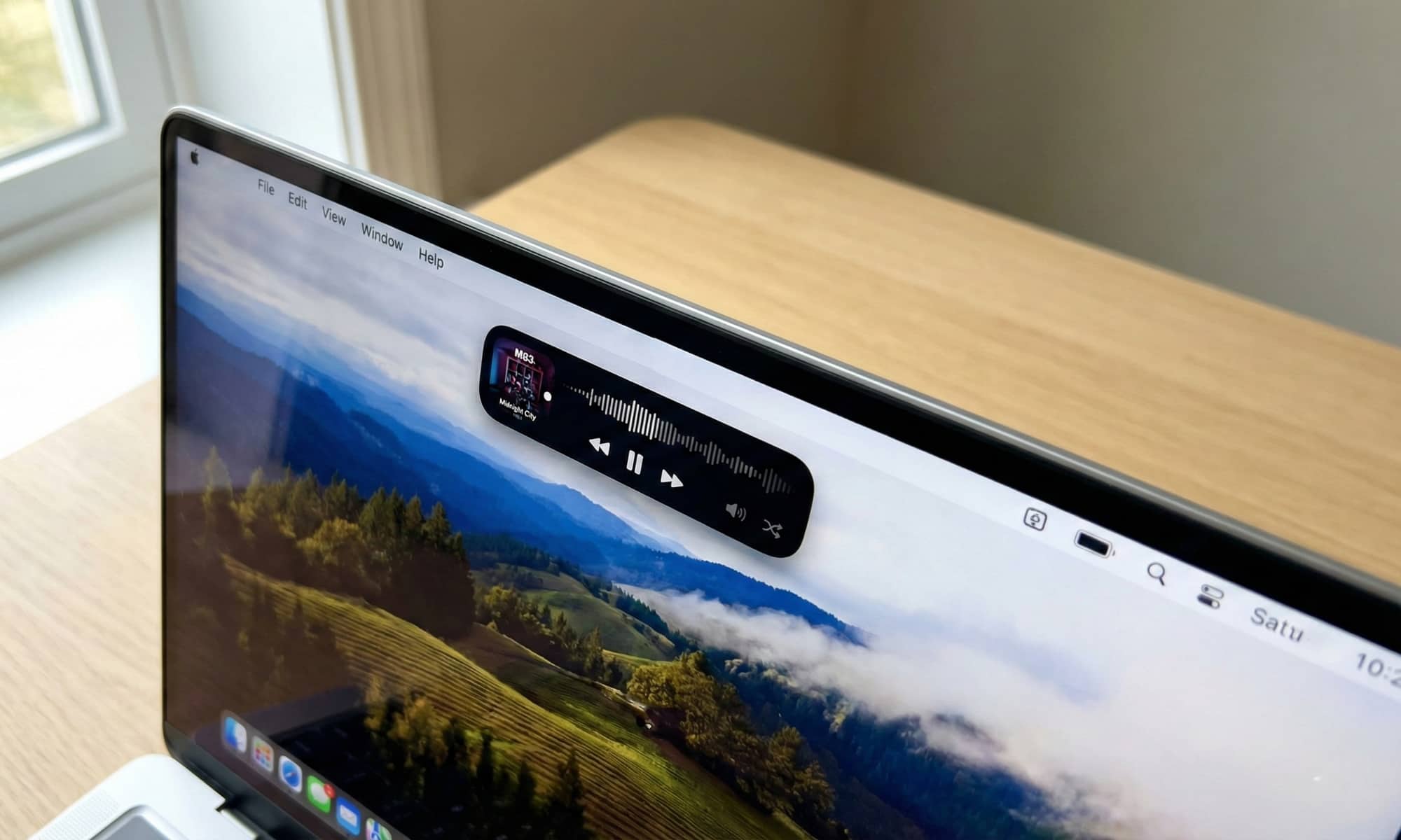 A concept image of the 2026 MacBook Pro&rsquo;s OLED display featuring an expanded Dynamic Island showing media controls.