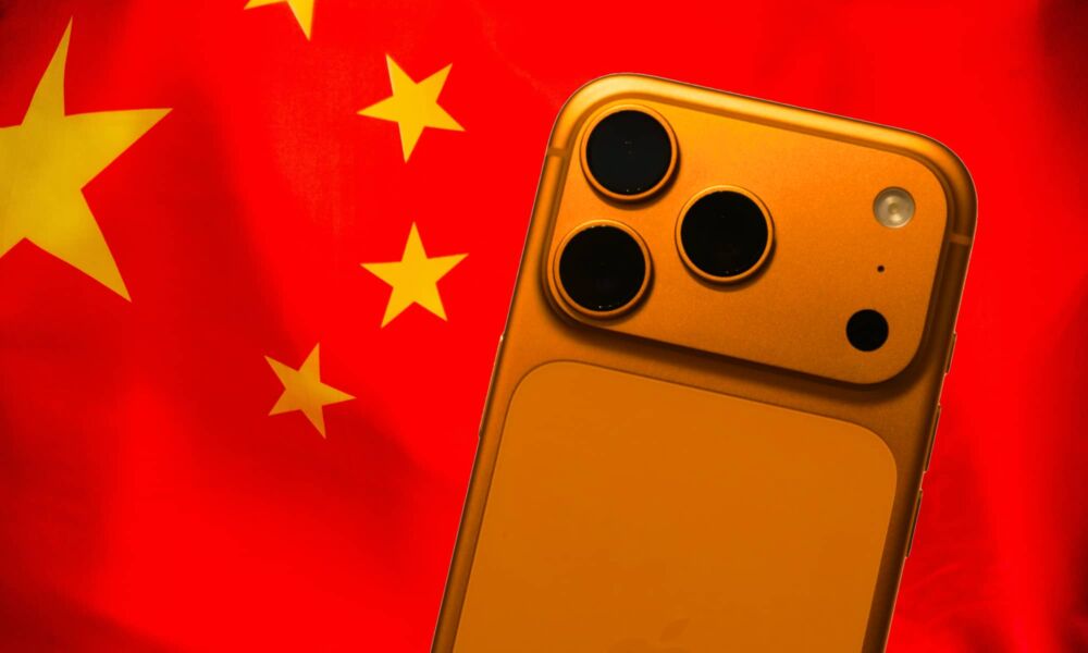 A vibrant Cosmic Orange iPhone 17 Pro displayed prominently in front of the red and gold five-star flag of China, symbolizing the model's massive success in the region.