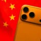A vibrant Cosmic Orange iPhone 17 Pro displayed prominently in front of the red and gold five-star flag of China, symbolizing the model's massive success in the region.