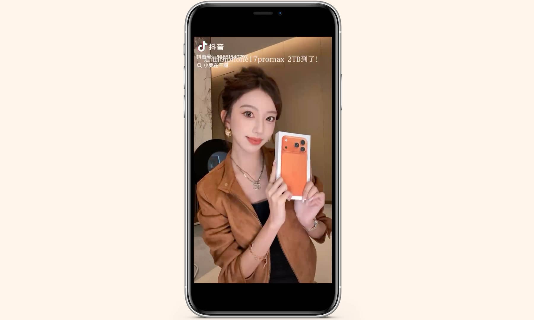 A screenshot from a viral social media video showing influencer Xiao Mei posing with a vibrant Cosmic Orange iPhone 17 Pro, which she compares to the signature color of luxury brand Herm&egrave;s.