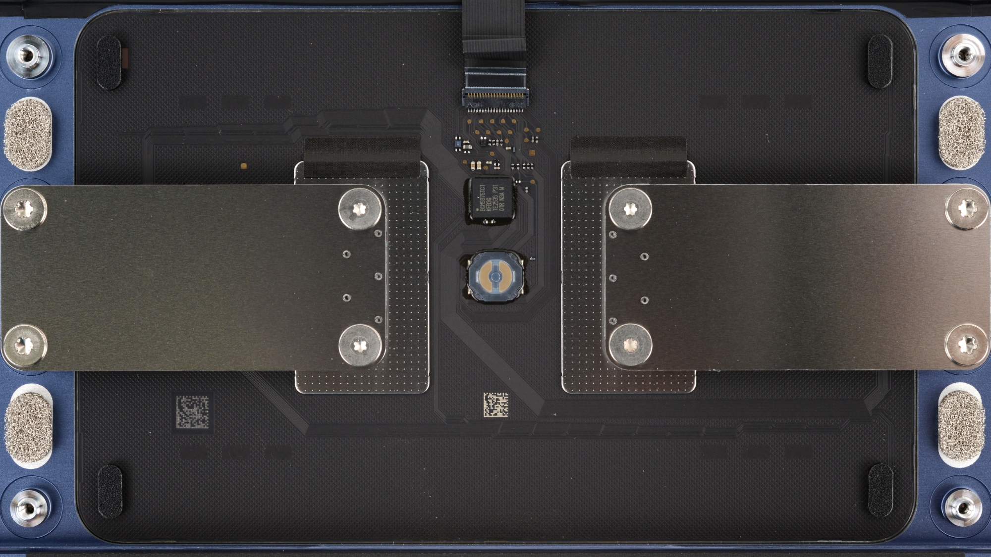 Macro shot of the MacBook Neo's mechanical trackpad mechanism, a simplified design that replaces the traditional Force Touch.