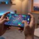A person playing a vibrant shooting game on a modern titanium iPhone in a stylish, dimly lit room.