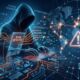 A conceptual digital illustration of a hooded hacker sitting at a glowing keyboard, surrounded by a dark blue and orange network grid showing a global map, a large warning triangle icon, and floating holographic text overlays that read 