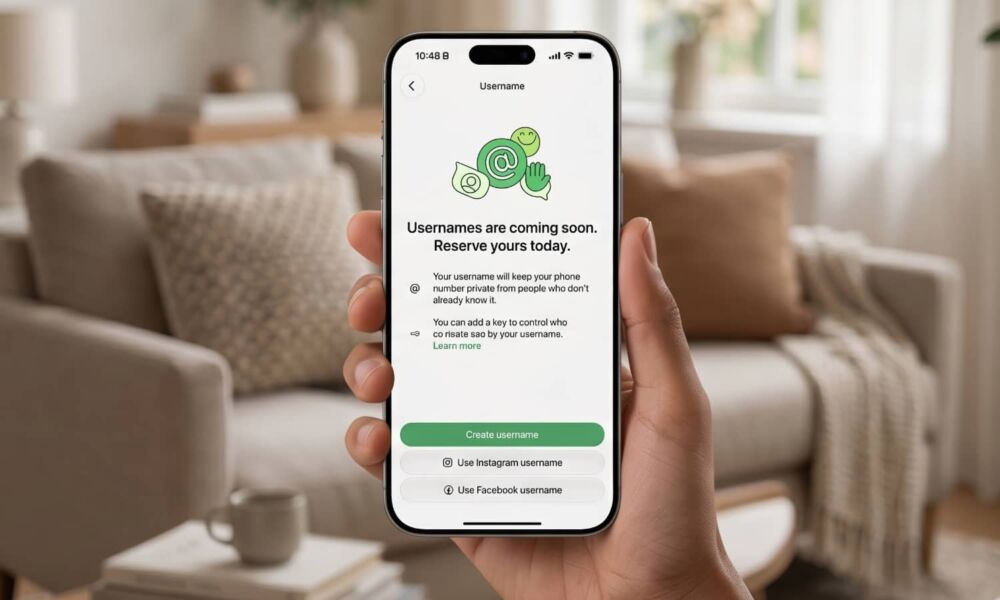 A hand holding an iPhone displaying the WhatsApp username reservation screen inside a modern, bright living room.