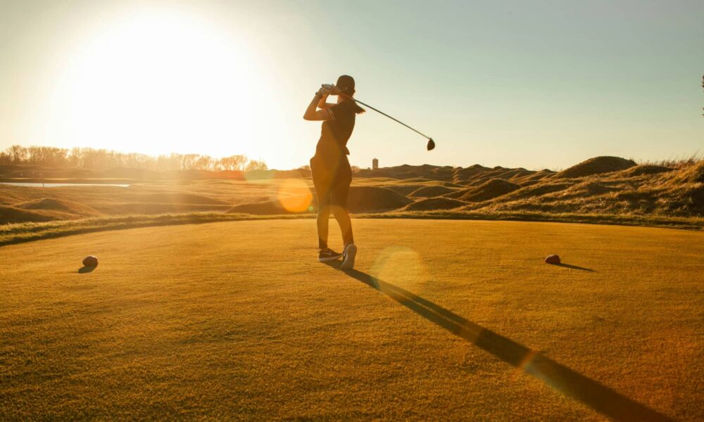 person swinging golf club