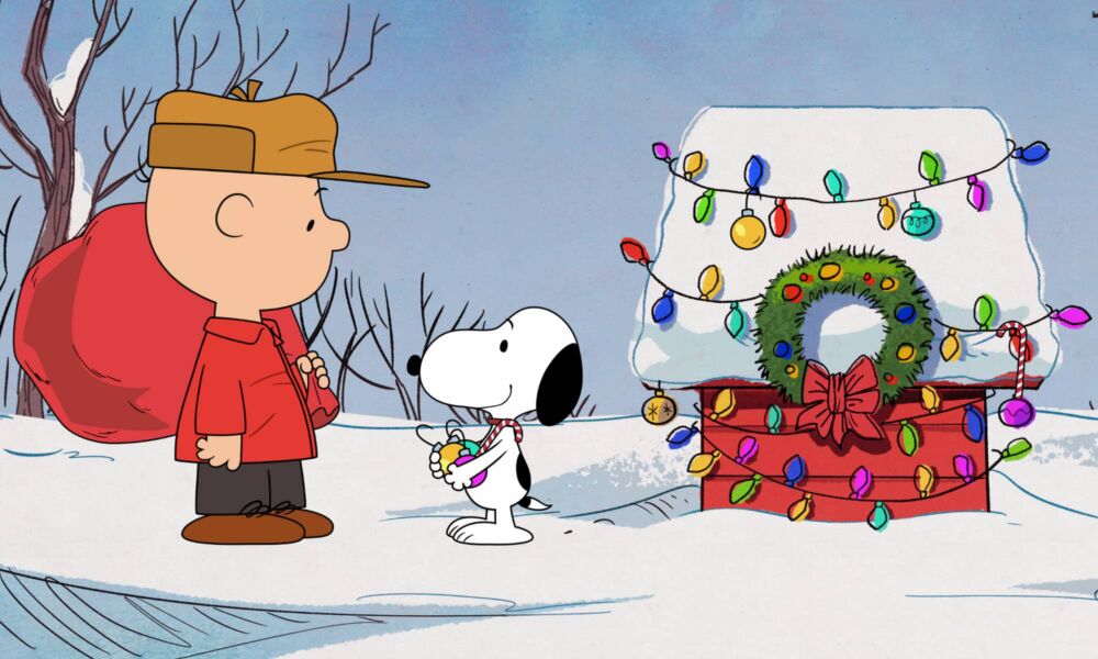 Image of Charlie Brown and Snoopy standing by the decorated doghouse in '12 Days of Snoopy'