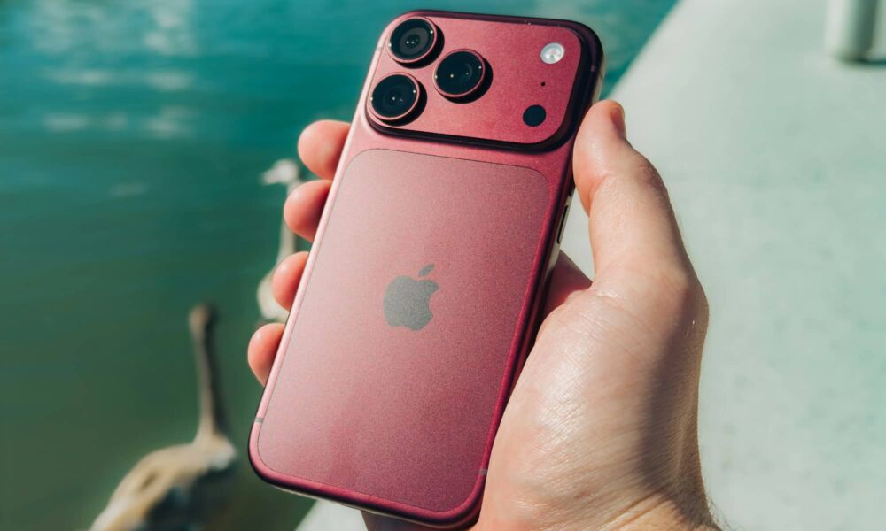 iPhone 18 Pro burgundy holding over pond