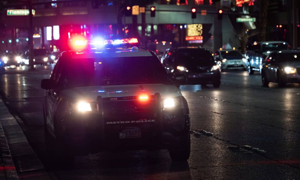 police car flashing lights dark city street