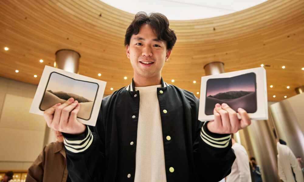 Custom at Apple Jingan Shanghai holding two iPhone Duo purchases on launch day.