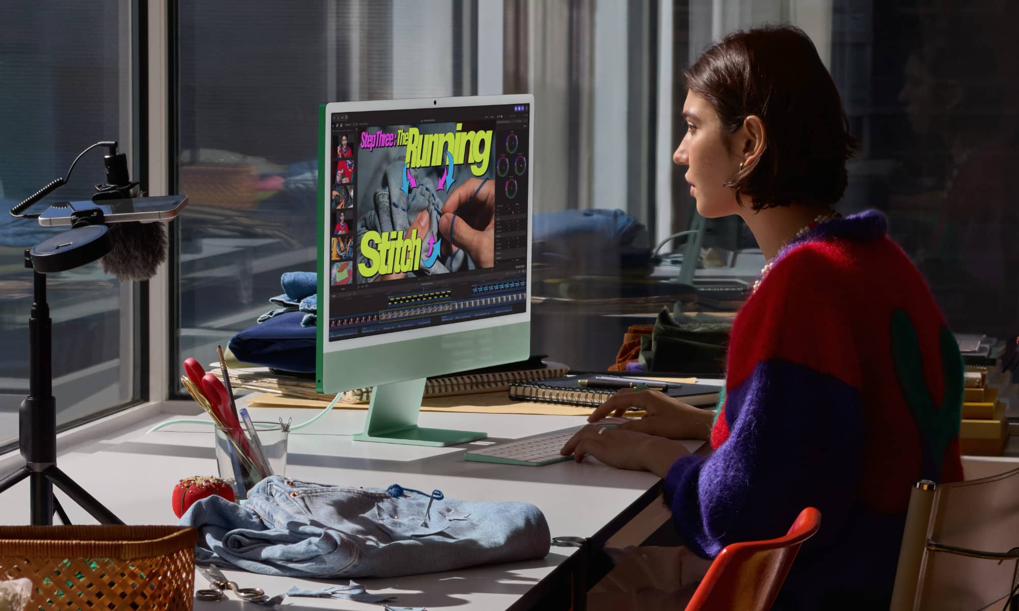 Woman sitting at desk editing a video on an Apple iMac with M6.