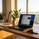 AI-generated concept image of a space black MacBook Pro with a vibrant OLED display and an iPad mini resting on a wooden studio desk in warm Los Angeles sunset light.